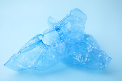 Photo of Pair of medical shoe covers on light blue background