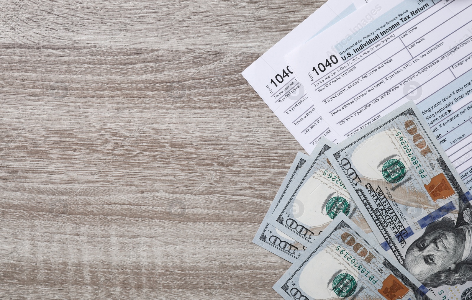 Photo of Payroll. Tax return forms, dollar banknotes and glasses on wooden table, flat lay. Space for text