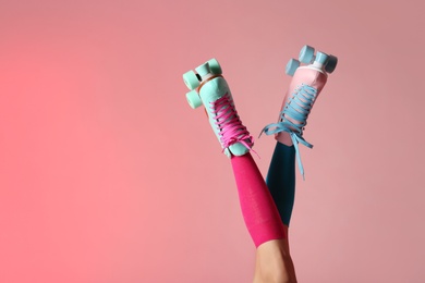 Photo of Woman with vintage roller skates on color background, closeup. Space for text