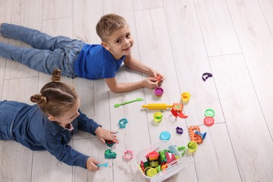 Photo of Cute little children playing on warm floor indoors, space for text. Heating system