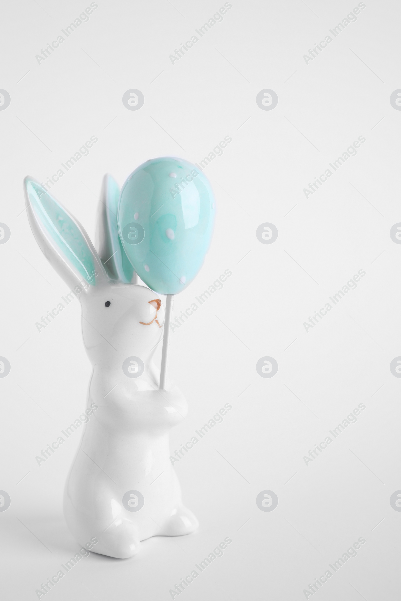 Photo of Bunny ceramic figure as Easter decor on white background