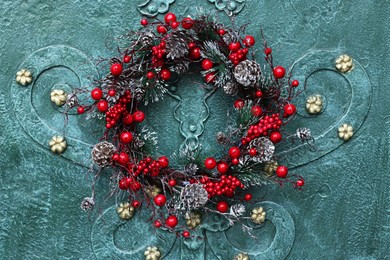 Beautiful Christmas wreath hanging on turquoise metal door