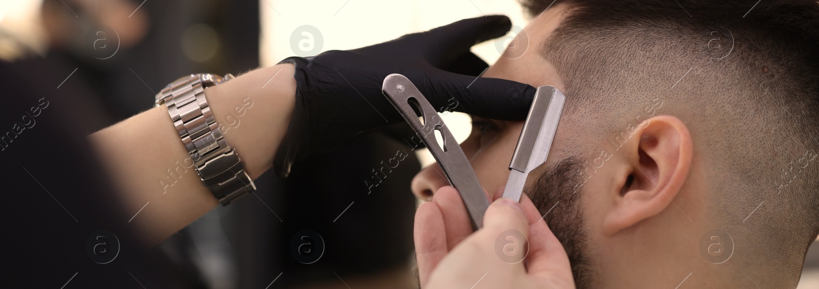 Image of Professional hairdresser working with client in barbershop, closeup. Banner design
