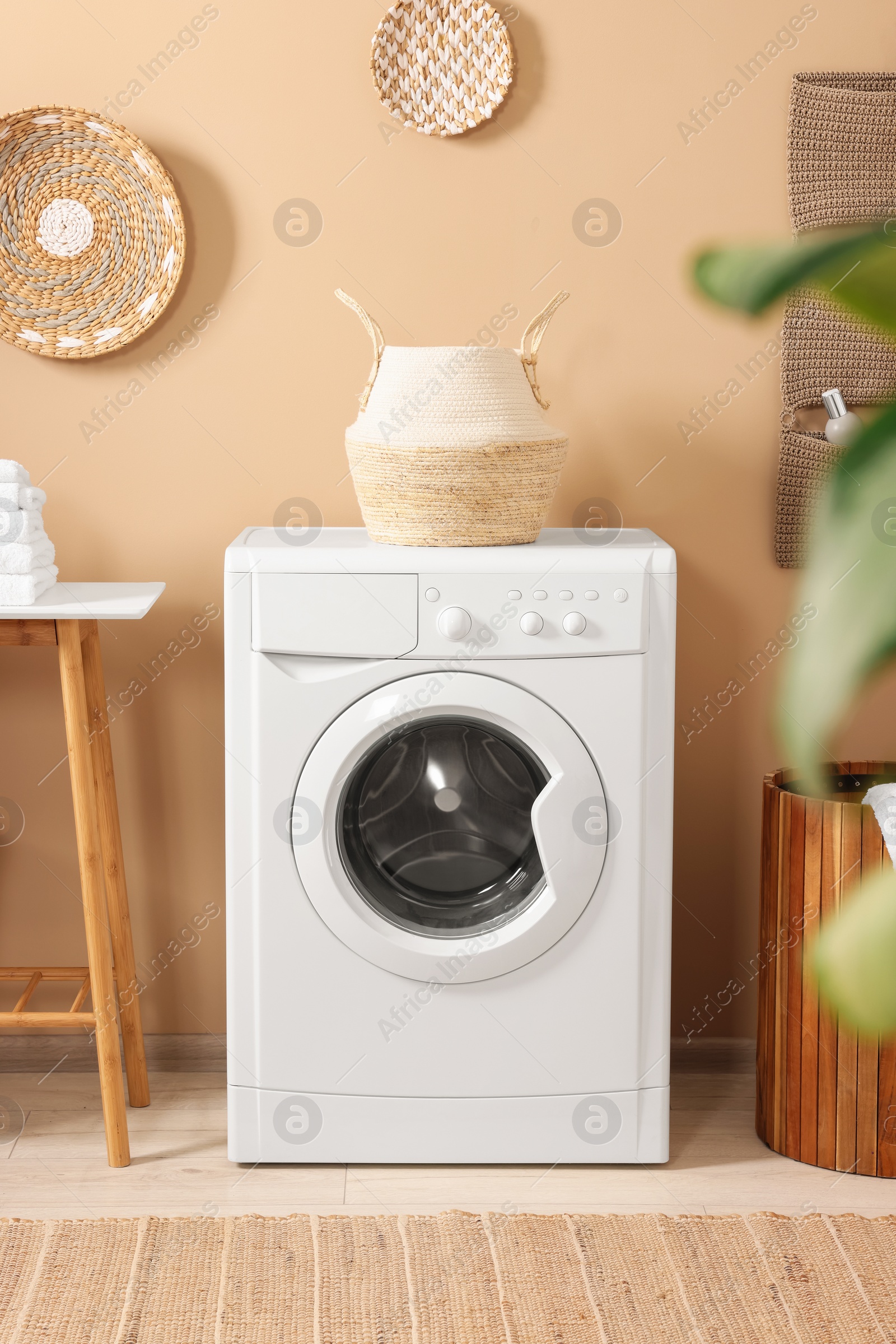 Photo of Stylish laundry room with modern washing machine. Interior design