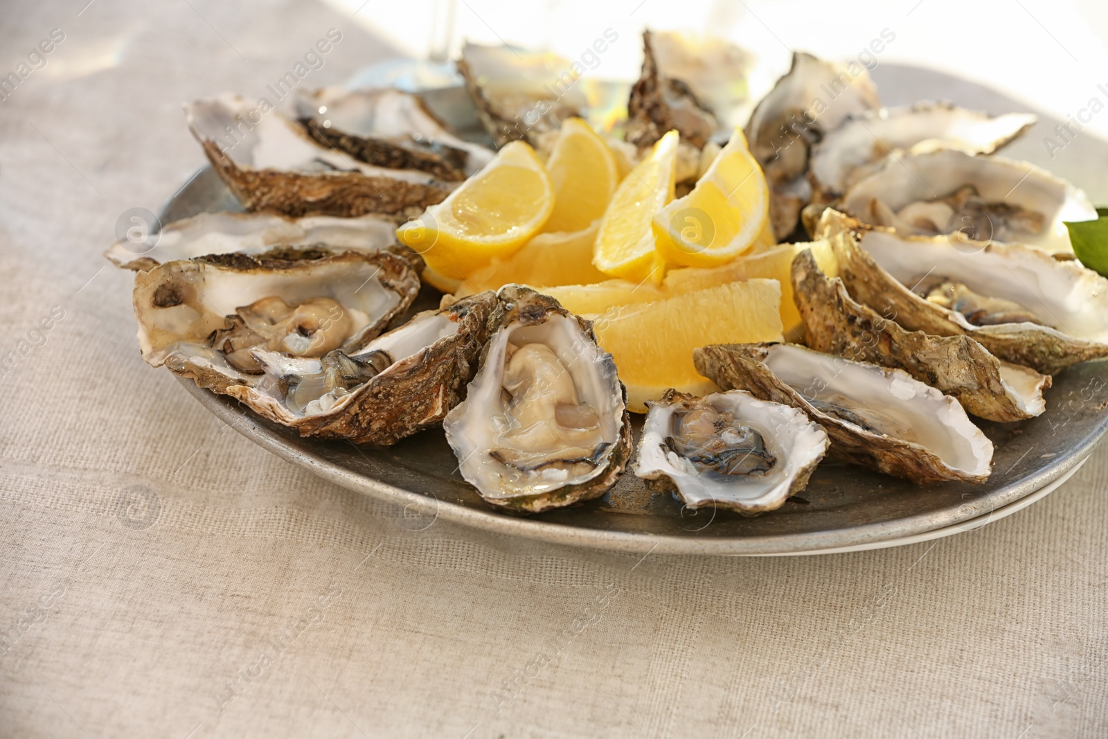 Photo of Fresh oysters with cut juicy lemon served on table