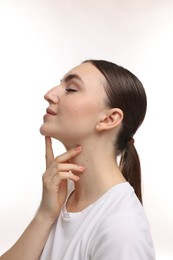 Beautiful woman touching her chin on white background