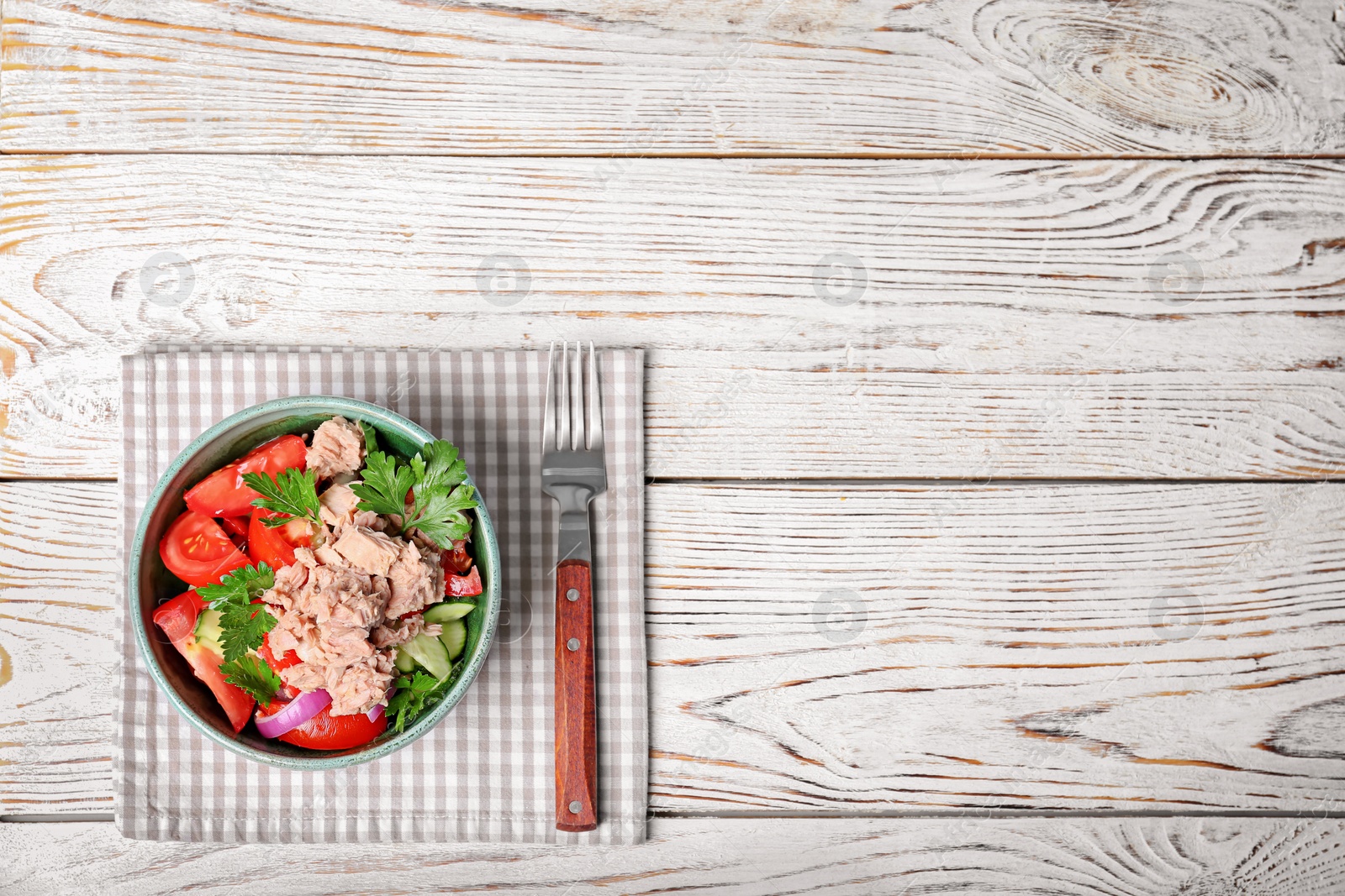 Photo of Delicious salad with canned tuna in bowl on wooden background, top view