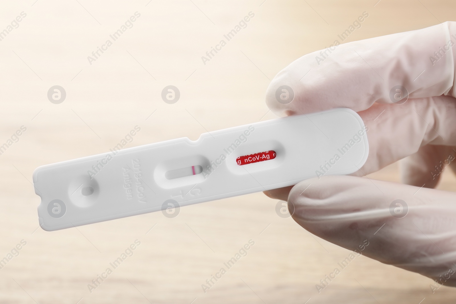 Photo of Doctor holding disposable Covid-19 express test on blurred background, closeup