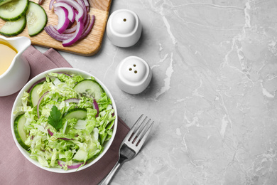 Flat lay composition with cabbage salad on light grey marble table. Space for text