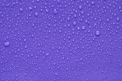 Photo of Water drops on lilac background, top view