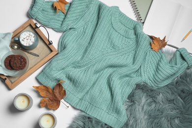 Flat lay composition with soft knitted sweater on white background