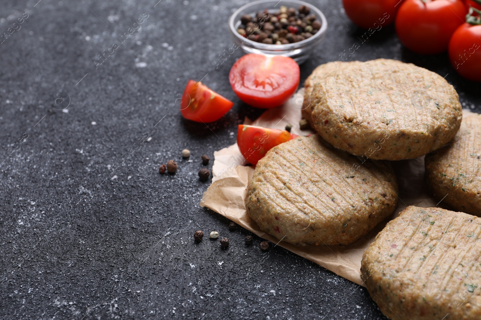 Photo of Tasty vegan cutlets and products on grey table, closeup. Space for text