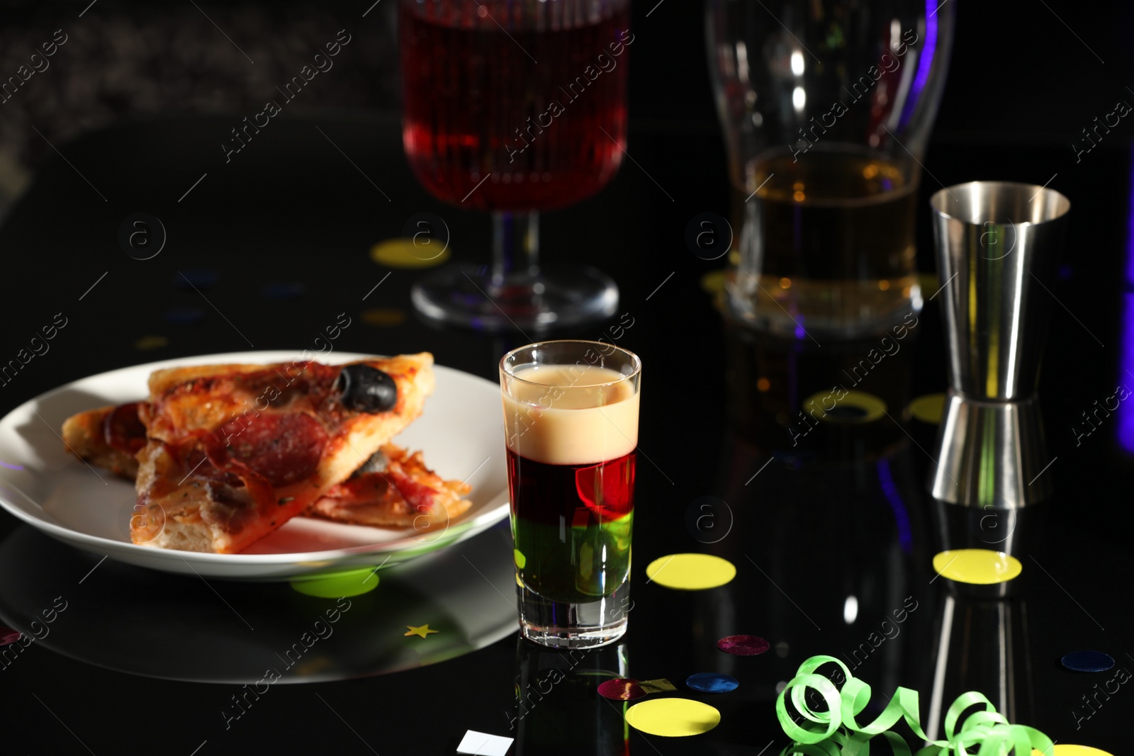 Photo of Bright delicious shot in glass and pizza on table