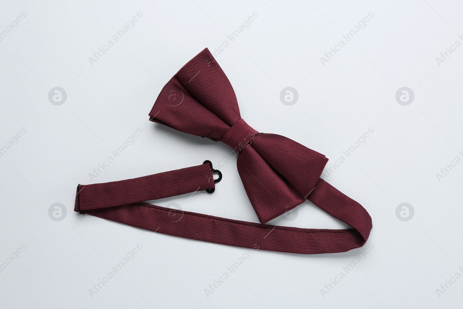 Photo of Stylish burgundy bow tie on white background, top view