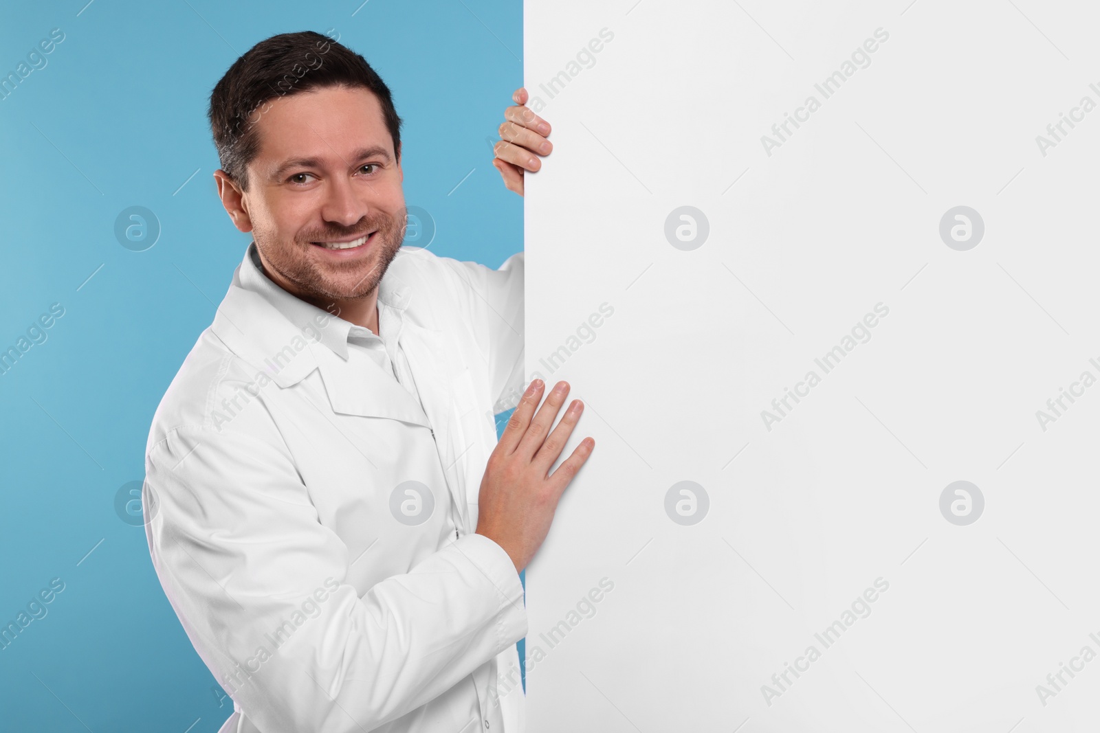 Photo of Ophthalmologist with blank banner on light blue background, space for text