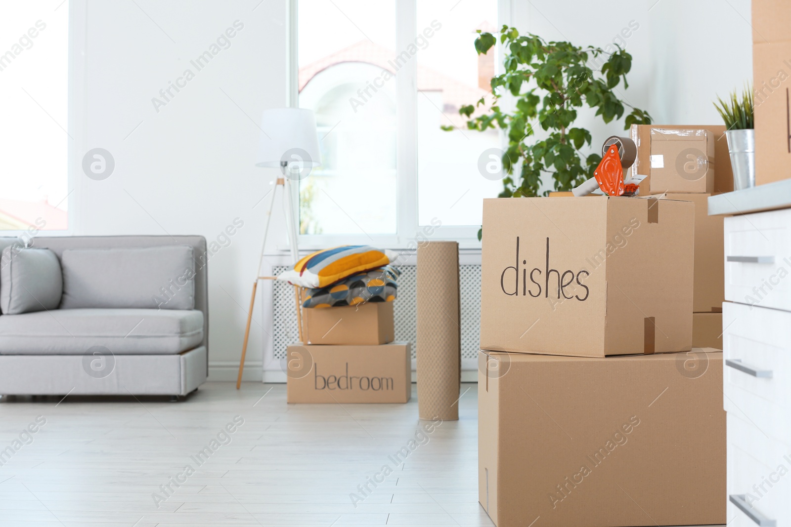 Photo of Moving boxes and household stuff indoors. Space for text