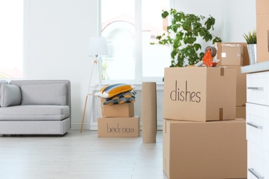 Photo of Moving boxes and household stuff indoors. Space for text