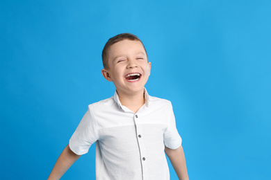 Photo of Portrait of cute little boy on blue background