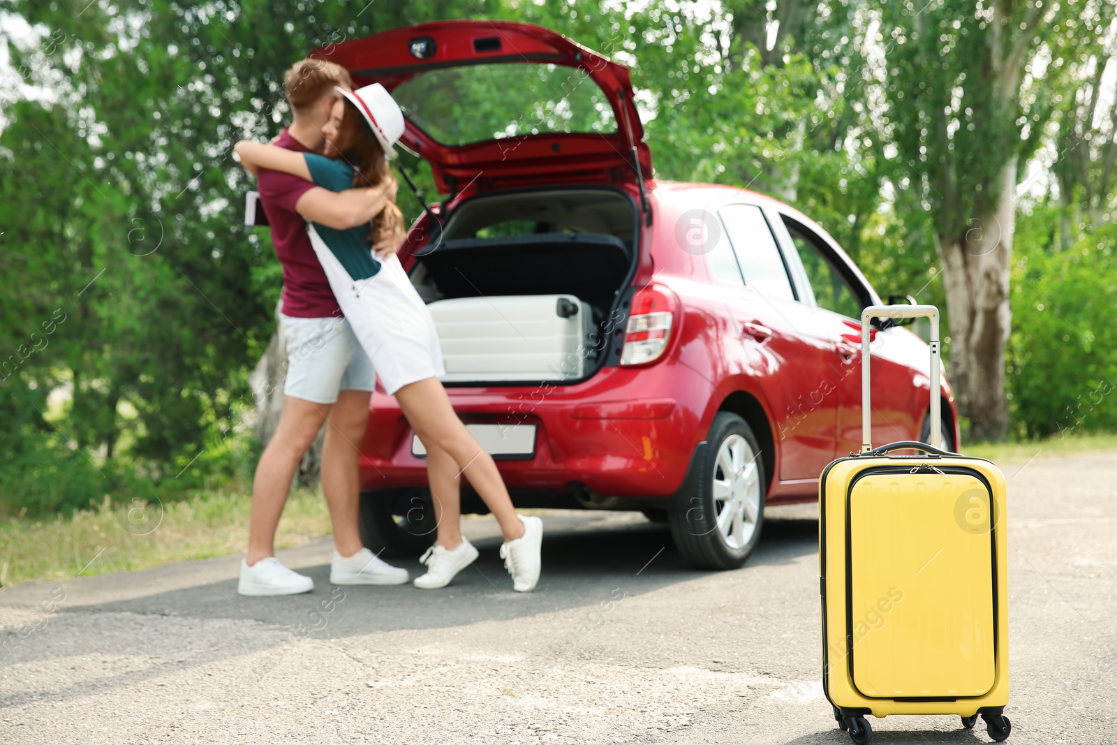Photo of Young couple with suitcases packed for summer journey near car