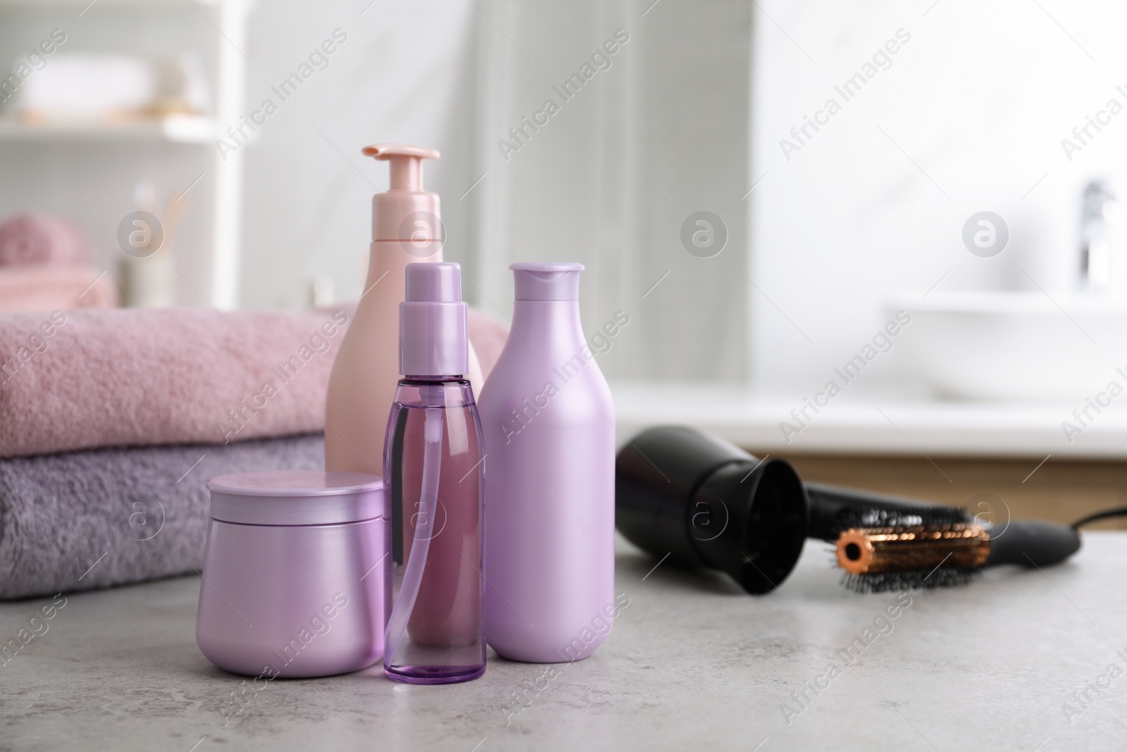 Photo of Different hair care products on table in bathroom, space for text