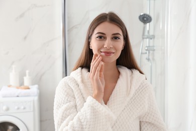 Photo of Young woman with clean fresh skin in bathroom