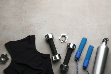 Photo of Flat lay composition with sportswear and equipment on grey table, space for text. Gym workout