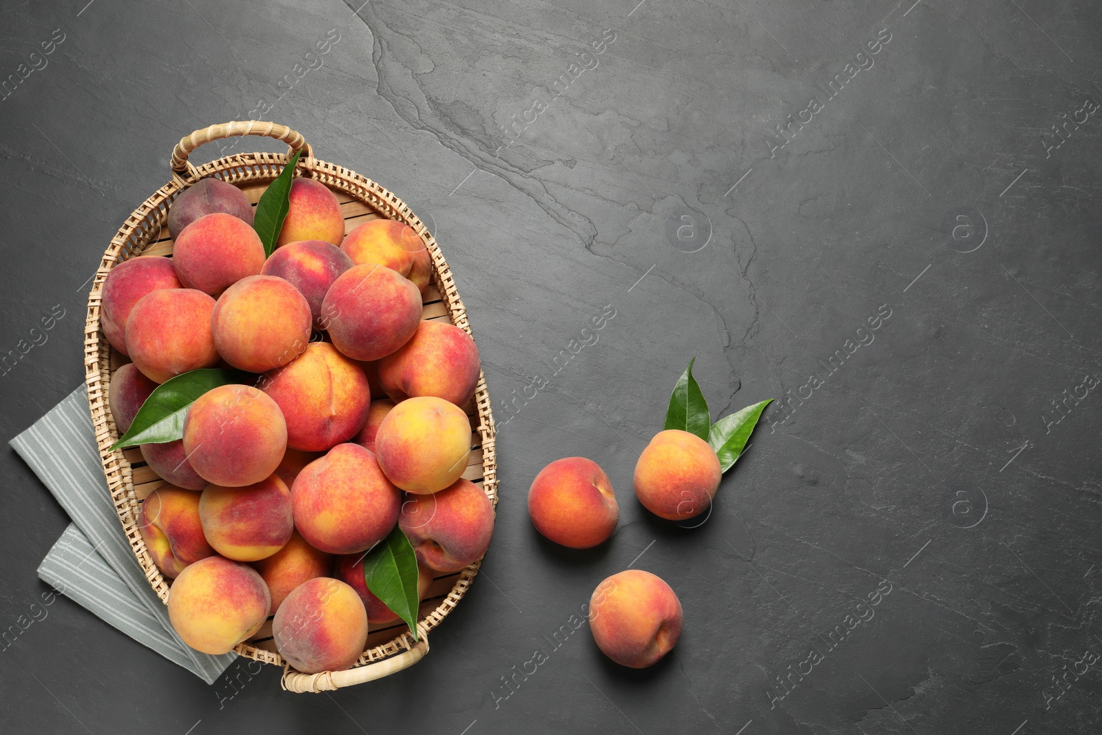 Photo of Fresh peaches and leaves on grey textured table, flat lay. Space for text