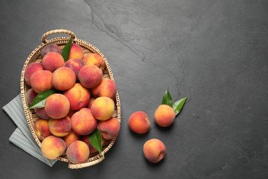 Fresh peaches and leaves on grey textured table, flat lay. Space for text