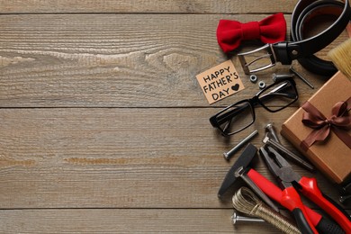 Photo of Card with phrase Happy Father's Day, different tools and men accessories on wooden background, flat lay. Space for text