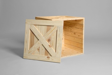 Photo of One open wooden crate on grey background