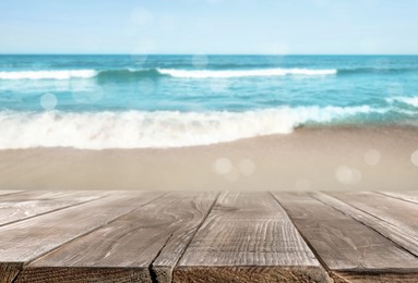 Image of Empty wooden table on beach near sea. Summer season