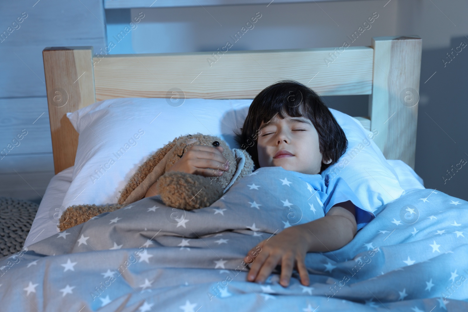 Photo of Cute little boy with toy bunny sleeping in bed at home