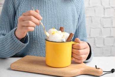 Photo of Woman eating snow ice cream at table, closeup