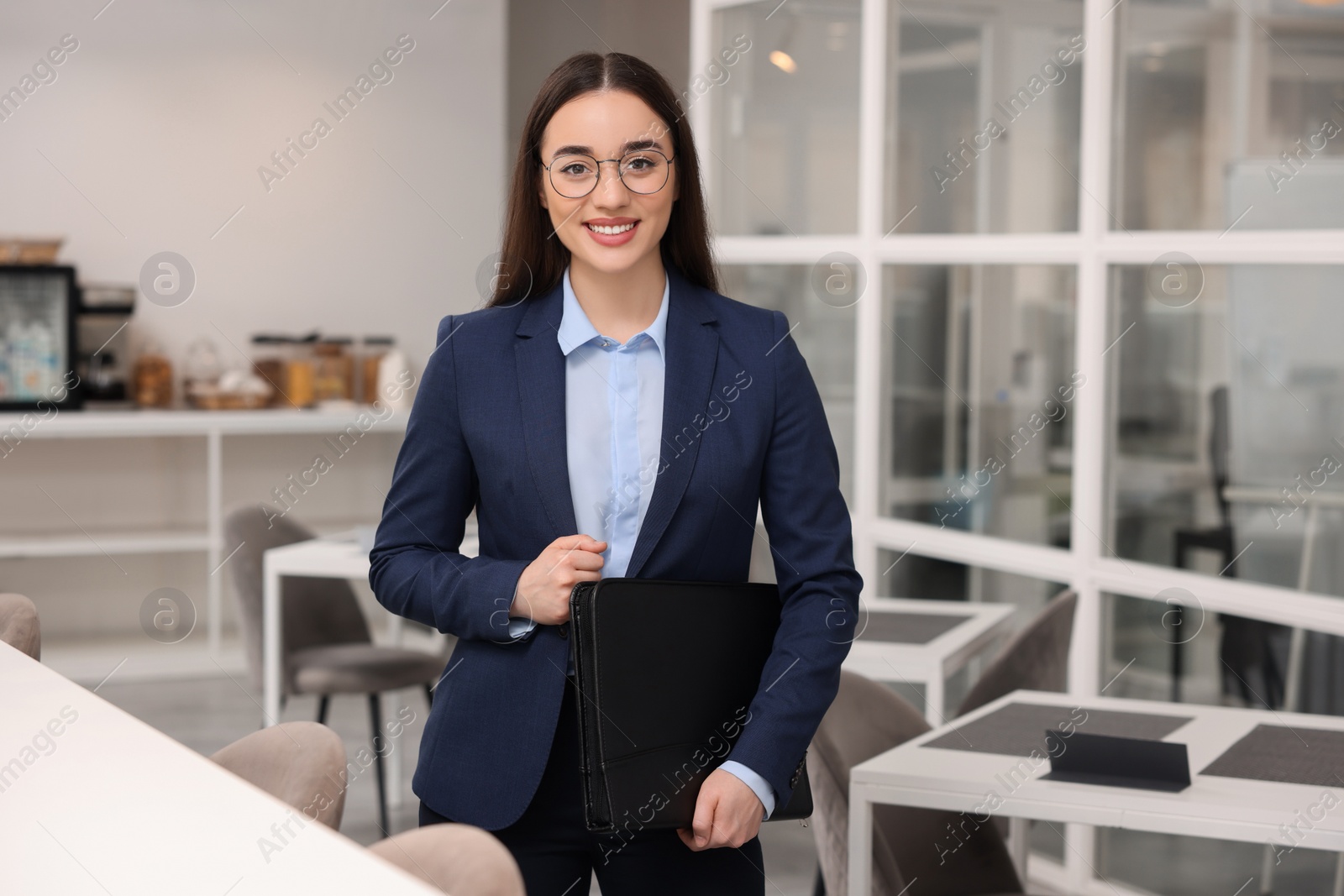 Photo of Happy real estate agent with leather portfolio in office