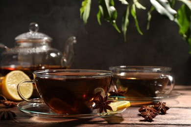 Photo of Aromatic tea with anise stars and lemon on wooden table