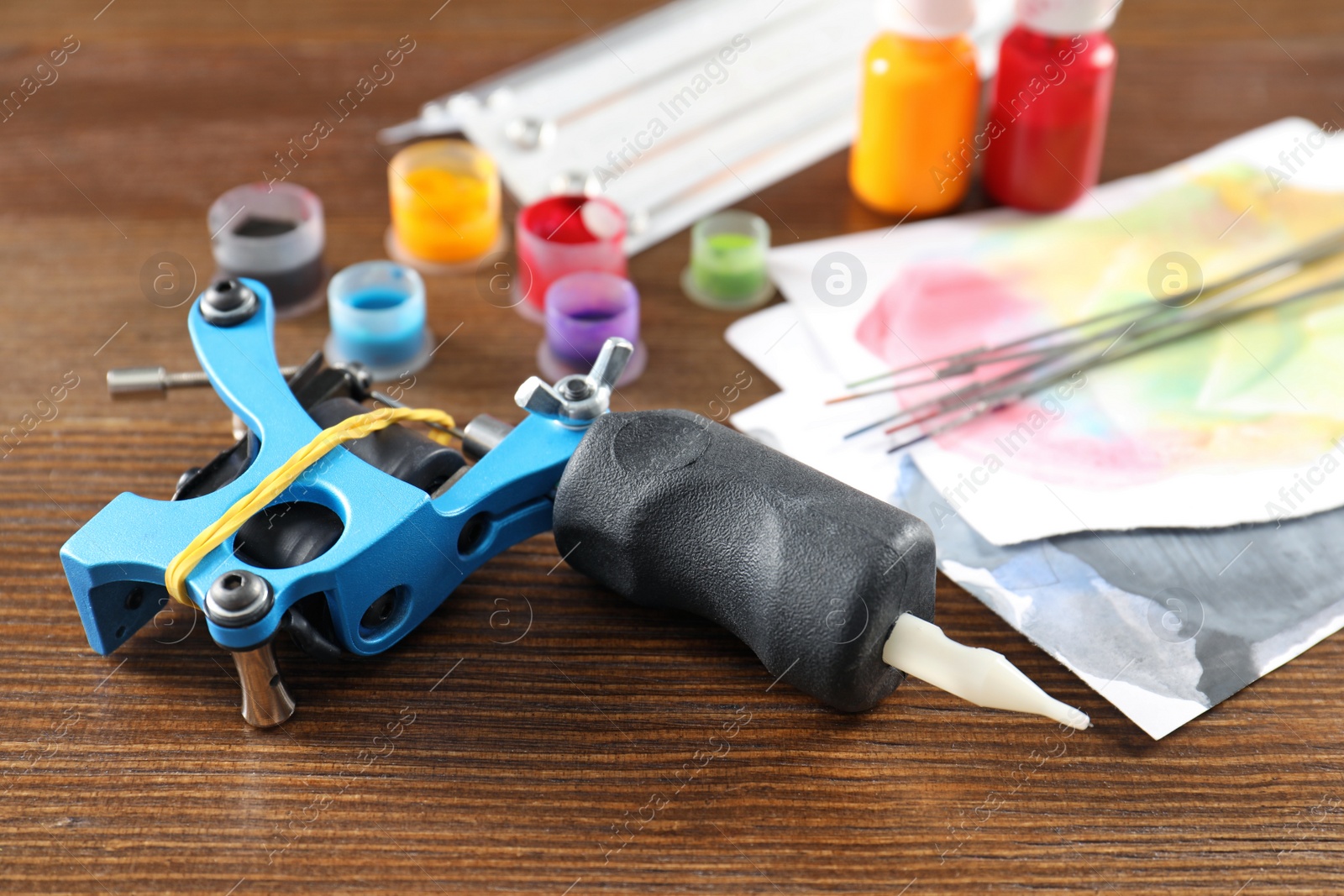 Photo of Composition with tattoo machine on wooden table