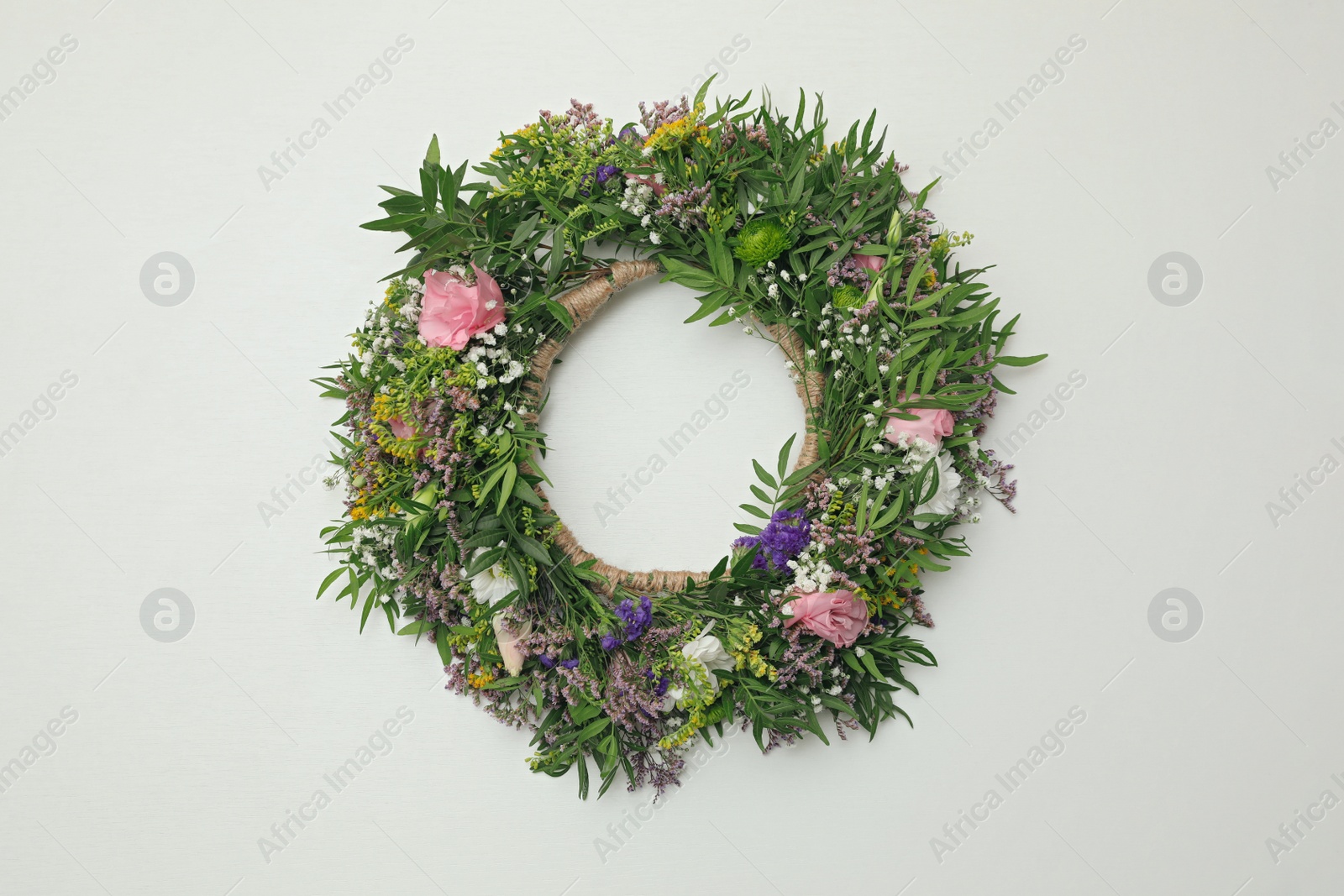Photo of Wreath made of beautiful flowers on white background, top view
