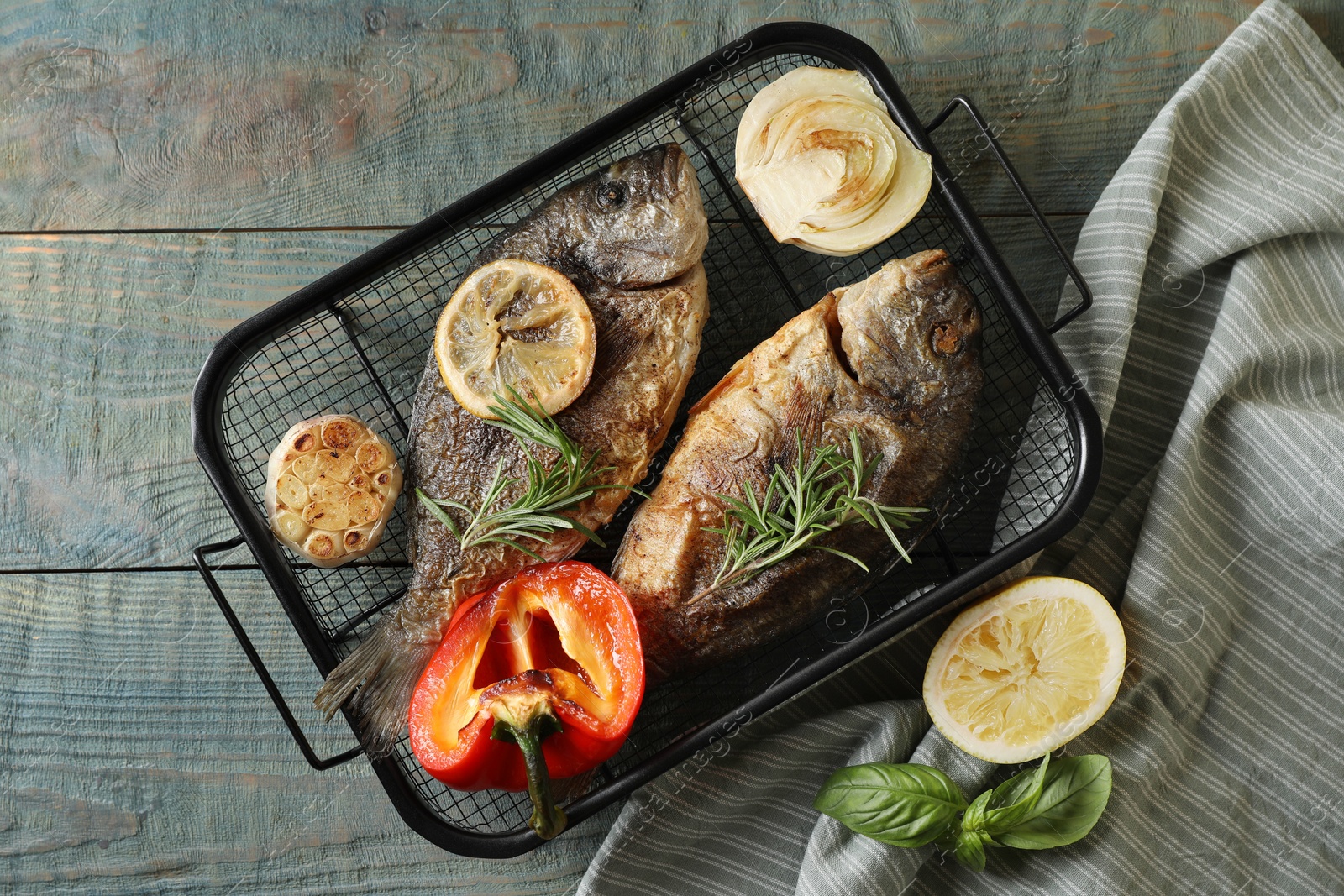 Photo of Delicious dorado fish with vegetables served on wooden table, flat lay