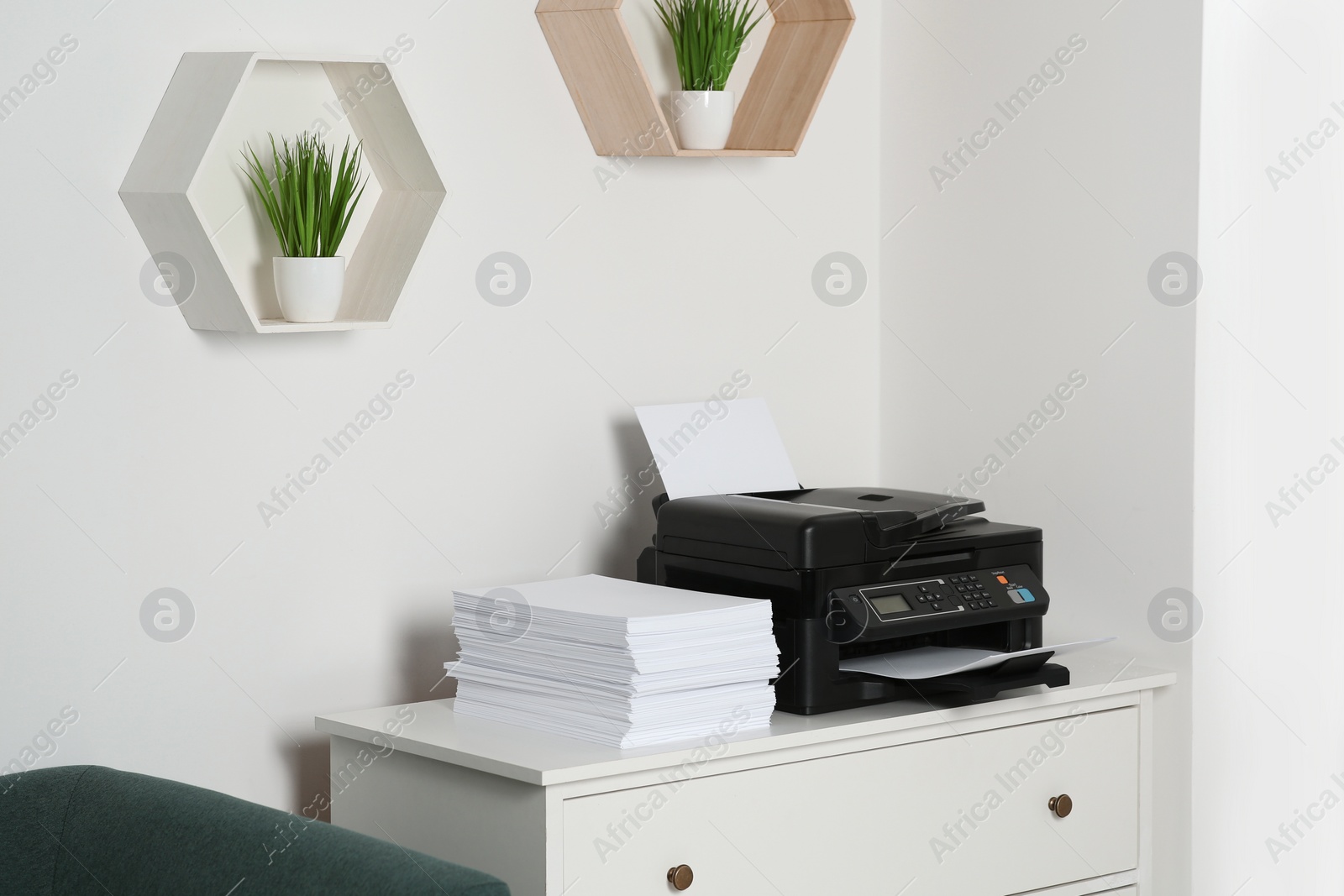 Photo of Modern printer and paper sheets on white chest of drawers indoors