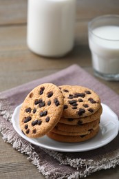 Photo of Delicious chocolate chip cookies and milk on wooden table