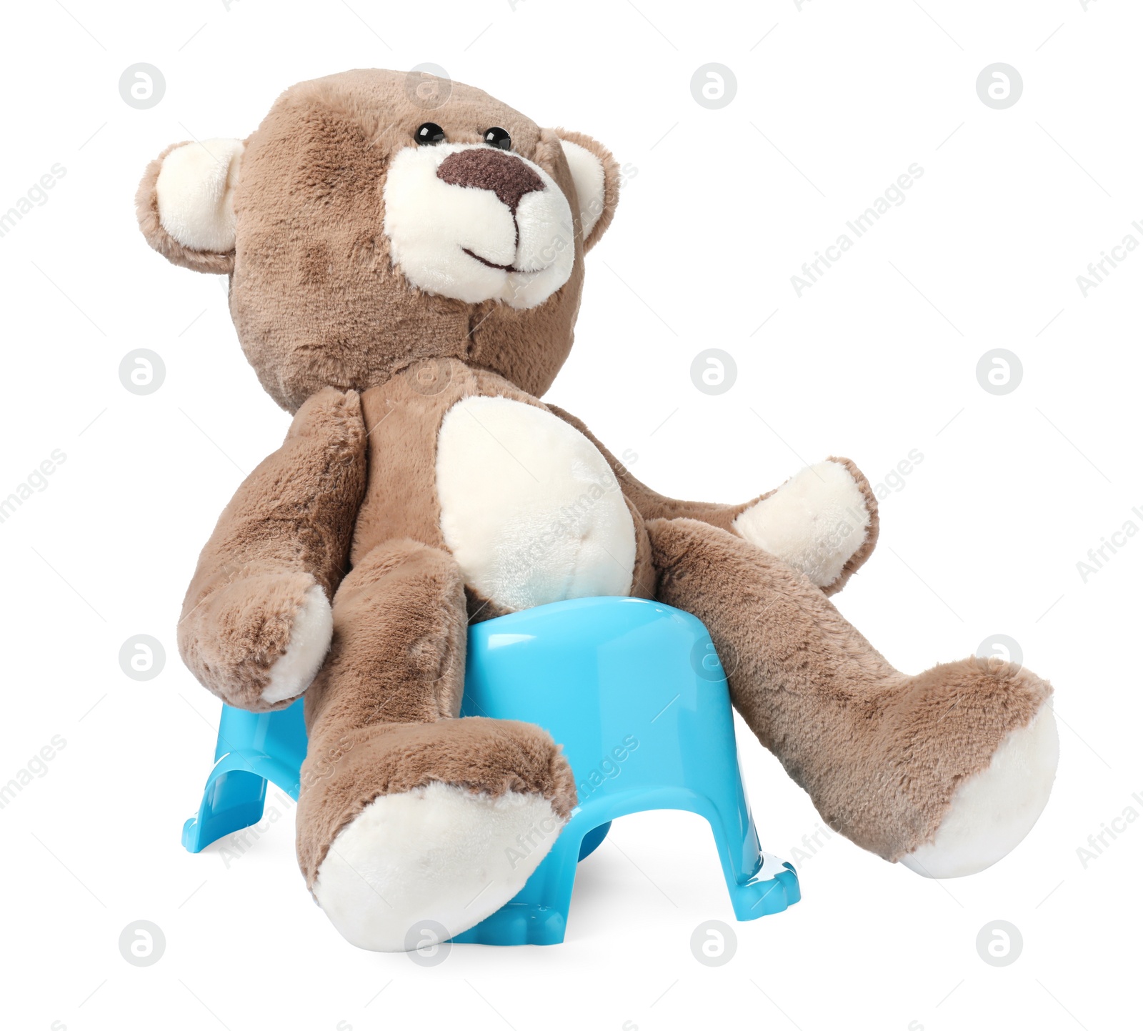 Photo of Teddy bear on light blue baby potty isolated on white. Toilet training