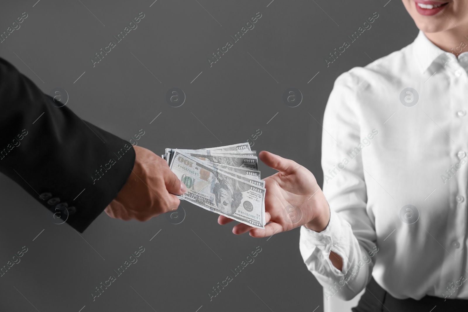 Photo of Man giving bribe money to woman on dark background, closeup