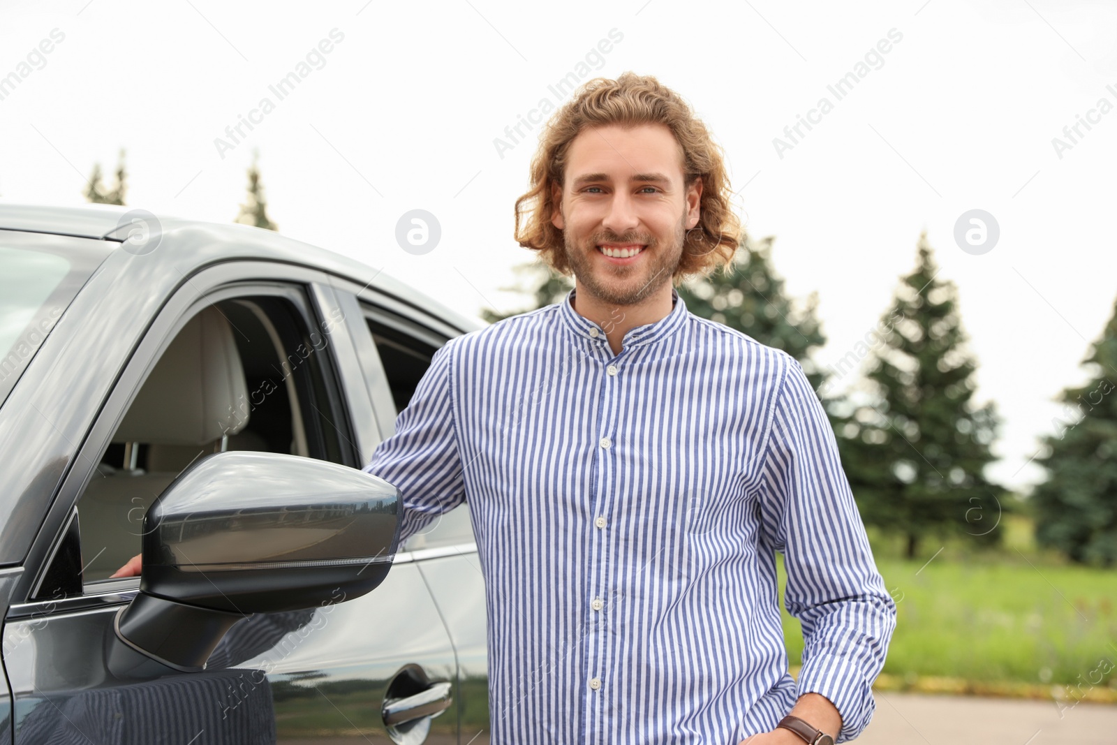 Photo of Attractive young man near luxury car outdoors