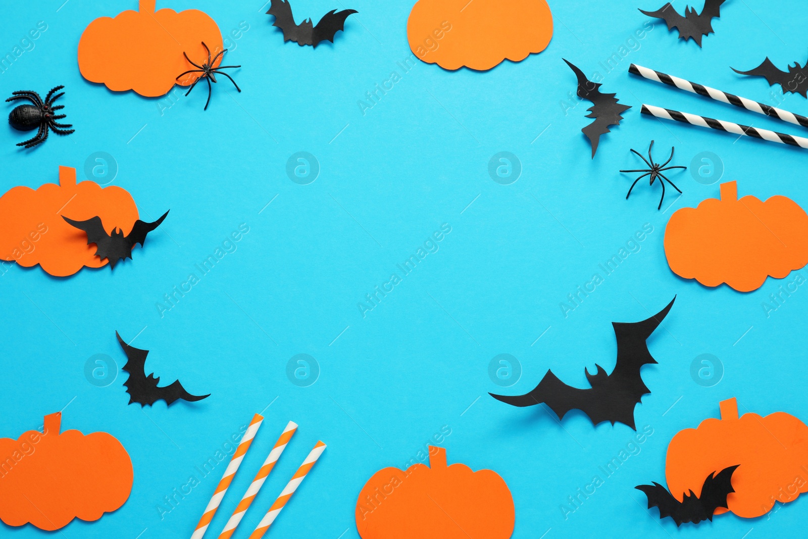 Photo of Frame made with Halloween decor elements on light blue background, above view. Space for text