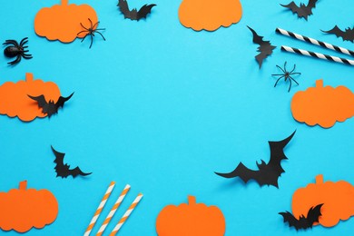 Frame made with Halloween decor elements on light blue background, above view. Space for text