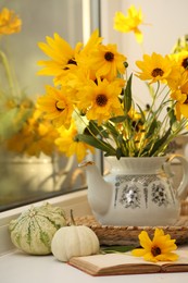 Photo of Composition with beautiful flowers, pumpkins and book on windowsill. Autumn atmosphere