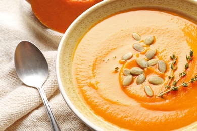 Photo of Bowl with tasty pumpkin soup on table, closeup