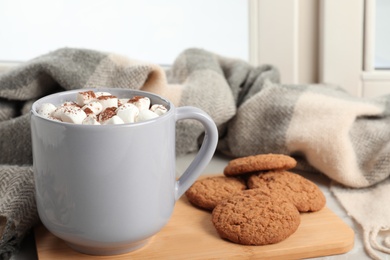 Composition with cup of cocoa and cookies on windowsill. Winter drink