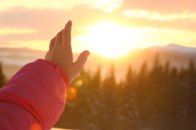 Photo of Young woman enjoying beautiful sunset outdoors, closeup view with space for text. Winter vacation