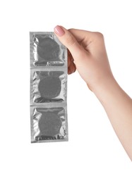 Woman holding condoms on white background, closeup